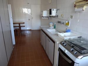 a kitchen with two sinks and a stove in it at Apartamento Pitangueiras in Guarujá