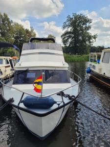 un bateau blanc est amarré dans l'eau dans l'établissement Amsterdam Boat & Breakfast, à Amsterdam