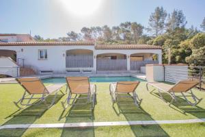 um quintal com cadeiras e uma piscina em love room avec spa et piscine vu panoramique em Solliès-Toucas