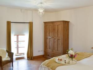 een slaapkamer met een bed, een dressoir en een raam bij Bagtor Hayloft in Haytor