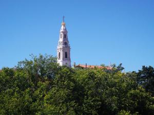 a white tower with a cross on top of a tree at Residencial Santa Clara in Fátima