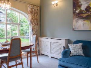 a living room with a table and chairs and a window at Coachman's Cottage in Pencombe