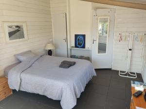 una camera da letto con un letto con una coperta blu di Chez Daniel & Catherine a La Chevrolière Altre 18 foto