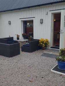 een patio met banken en potplanten voor een gebouw bij Raselund Gård in Vinninga