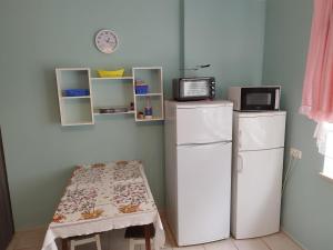 a kitchen with a refrigerator and a table and a microwave at Pokoje Gdańska in Żyrardów