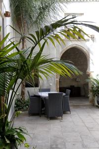 un patio con mesa, sillas y palmeras en Riad Dar Zen en Rabat