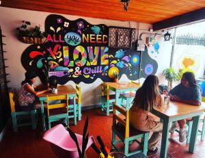 Dos mujeres sentadas en mesas en un restaurante en Chillout Hostel Barrio Escalante en San José