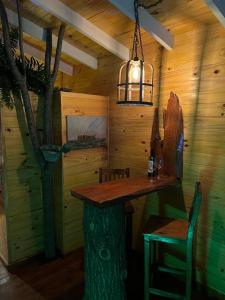una zona de comedor en una cabaña con una mesa de tocón de árbol en La Casa Del Arbol con pileta privada en Capilla del Señor