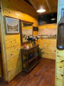 Habitación de madera con una mesa con flores. en La Casa Del Arbol con pileta privada en Capilla del Señor