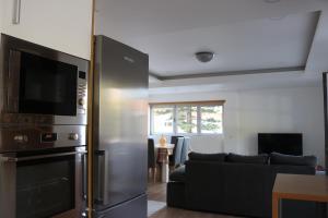 uma sala de estar com um frigorífico e um sofá em Casa da Fonte Quente em Leiria