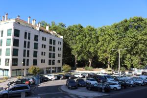 a parking lot with cars parked in front of a building at Casa da Fonte Quente in Leiria