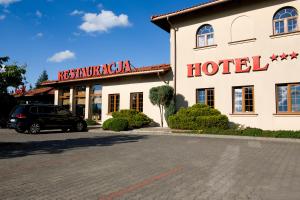 hotel z samochodem zaparkowanym przed nim w obiekcie HOTEL LEMONIADA w mieście Lućmierz