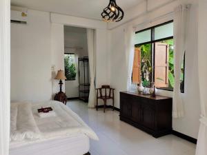 a white bedroom with a bed and a window at Destiny Home Stay 