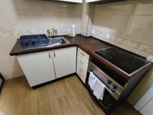 a small kitchen with a sink and a stove at Sunny flat with huge terrace! Close downtown! in Alicante