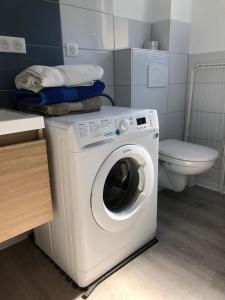 a washing machine in a bathroom with a toilet at Quiet Corner in Colmar