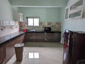a kitchen with brown cabinets and a window in it at Ramya Grand in Visakhapatnam