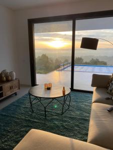 a living room with a table and a large window at Villa White Lagoon, 6 guests, 2 bathrooms, heated private pool, amazing view, AC, fully Equiped ! in Alfeizerão +13 photos