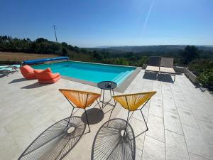 un patio con 2 taburetes y una piscina en Villa White Lagoon, 6 guests, 2 bathrooms, heated private pool, amazing view, fully Equiped ! en Alfeizerão
