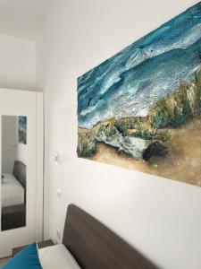 un dipinto dell'oceano sulla parete di una camera da letto di Elementi Luxury House a Otranto