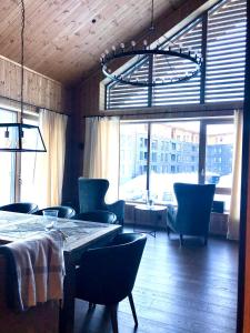 a dining room with tables and chairs and a large window at Fyri Tunet Hemsedal in Hemsedal