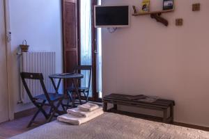 a room with a bed and two chairs and a tv at 4 Camere A Trani in Trani