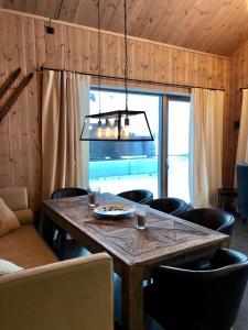 Fyri Tunet Hemsedal في هيمسيدال: غرفة طعام مع طاولة وكراسي خشبية