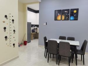 uma sala de jantar com mesa e cadeiras em My Homestay Sitiawan - Astronaut Space House 8 Pax em Sitiawan