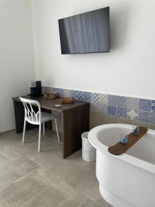 y baño con escritorio, silla y bañera. en Elementi Luxury House en Otranto