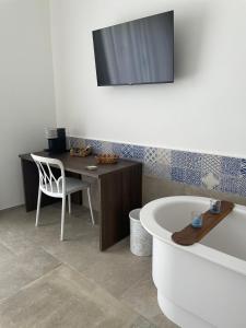 a bathroom with a desk and a chair and a tub at Elementi Luxury House in Otranto
