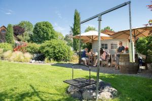 eine Gruppe von Menschen, die an einem Tisch im Hof sitzen in der Unterkunft Landhaus Hoher in Oberteuringen