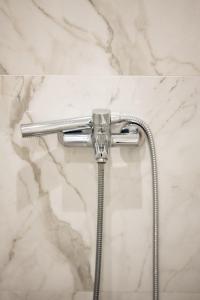baño con ducha y pared de mármol en A casa nostra, en Loutraki