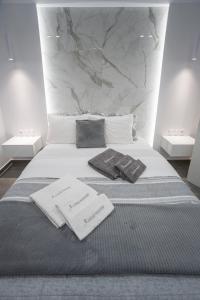 een bed met twee kussens en handdoeken erop bij A casa nostra in Loutraki