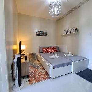 - un salon avec un lit et une télévision dans l'établissement Brenthill Condo Suite, à Baguio