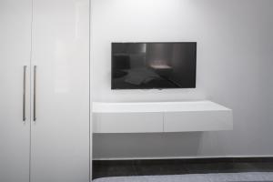 a tv on top of a white wall at A casa nostra in Loutraki