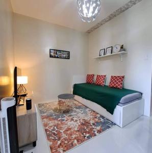 - un salon avec un canapé et une table dans l'établissement Brenthill Condo Suite, à Baguio