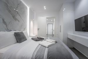 een witte slaapkamer met een groot bed met handdoeken erop bij A casa nostra in Loutraki