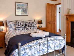 パーにあるBay Cottageのベッドルーム1室(青と白のベッド、ランプ2つ付)