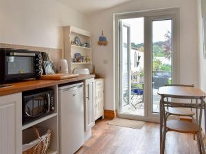 a kitchen with a counter with a dishwasher at Bay Cottage in Par