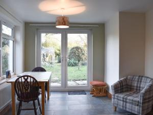 ein Esszimmer mit einem Tisch, Stühlen und einem Fenster in der Unterkunft Lansdowne in Dousland