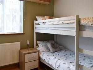 1 dormitorio con 2 literas y mesa en Lansdowne en Dousland