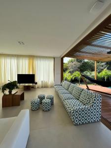 - un salon avec un canapé et une télévision dans l'établissement Casa em Praia do Forte - Bahia, à Praia do Forte