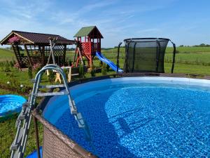 una piscina con scivolo e un parco giochi di Domek letniskowy a Giby