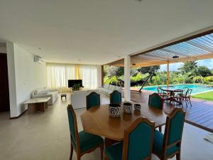 uma sala de jantar e sala de estar com mesa e cadeiras em Casa em Praia do Forte - Bahia em Praia do Forte
