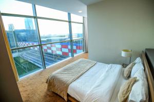 a bedroom with a bed and a large window at Avenue Hotel Baku by Smart in Baku