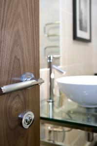 a bathroom with a wooden door with a sink at Buchan Braes Hotel in Peterhead