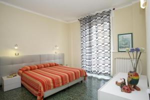 a white bedroom with a bed and a window at Riviera Apartments in Levanto