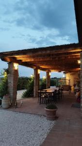 a wooden pergola with tables and chairs on a patio at La Rugantina in Cortona