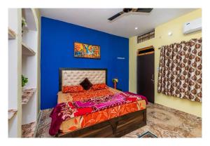 1 dormitorio con 1 cama con pared azul en Orchha Best Homestay en Orchha