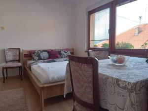 a bedroom with a table and a bed and a table and chairs at Apartmani Emir in Visoko