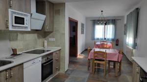 cocina con fregadero y mesa con sillas en Casa rural La Colmena del Geoparque, en Navatrasierra